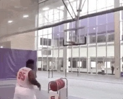 Basketball player taking a practice shot in an empty gym