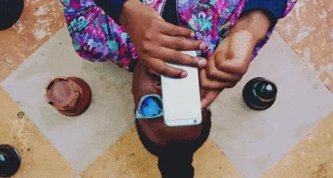 Person lying on a tiled floor scrolling through a phone